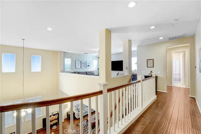 a view of a hallway with wooden floor and windows