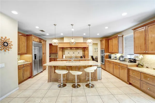 a large white kitchen with a large window and stainless steel appliances