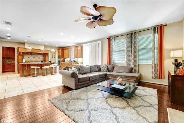 a living room with furniture kitchen view and a large window