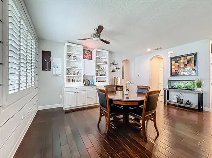 a dining room with wooden floor a chandelier a wooden table and chairs