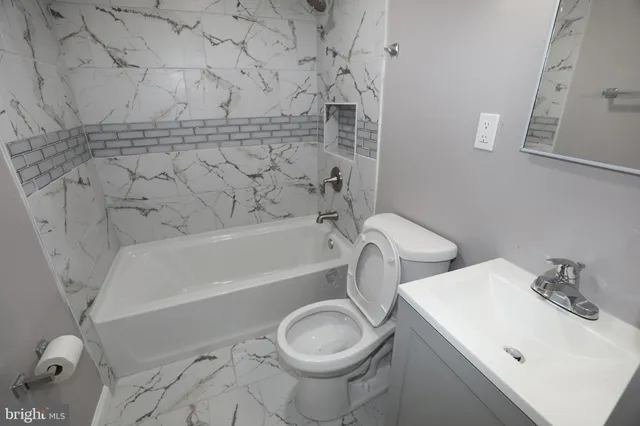 a bathroom with a sink a toilet and bathtub