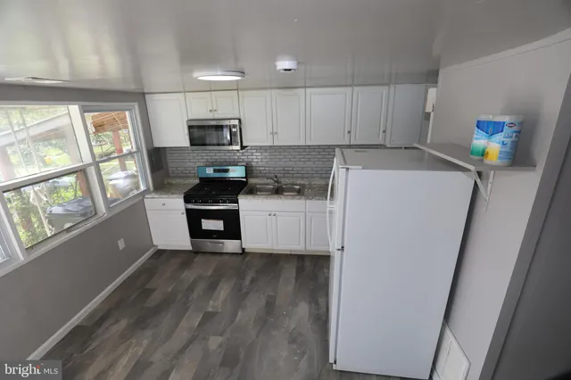 a kitchen with stainless steel appliances a refrigerator sink and microwave