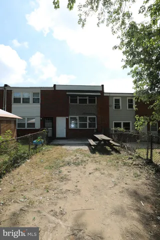 a backyard of a house with barbeque oven and outdoor seating