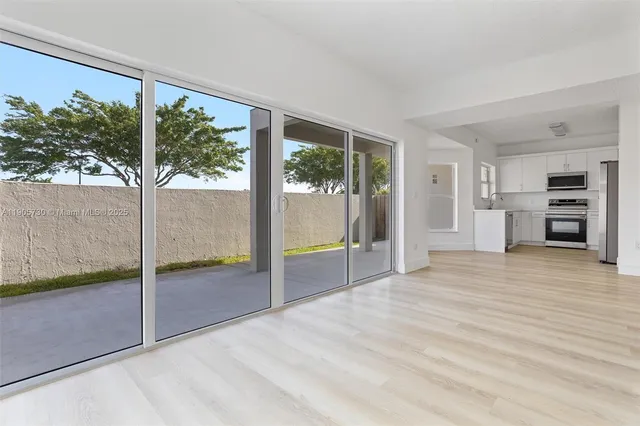 a view of empty room with floor to ceiling window and an outdoor view