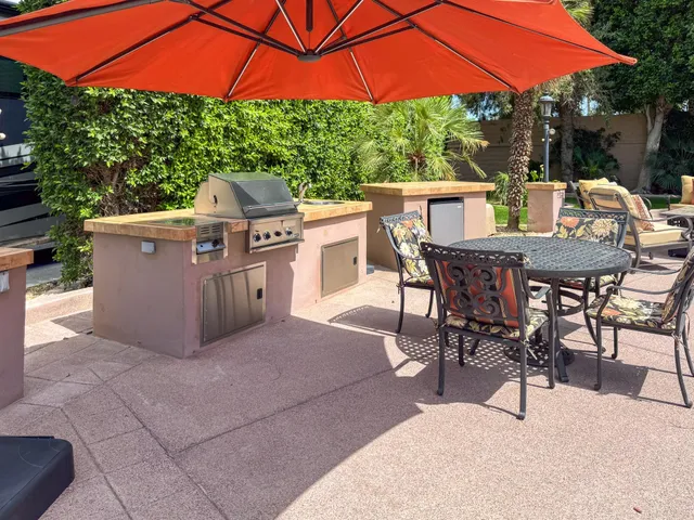 a view of a patio with a table and chairs under an umbrella
