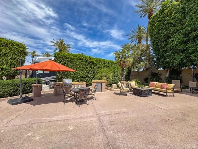 a view of a patio with a table and chairs under an umbrella