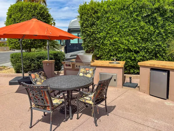 a view of a patio with table and chairs under an umbrella