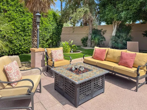a outdoor space with patio couches and a potted plant on a table and chairs