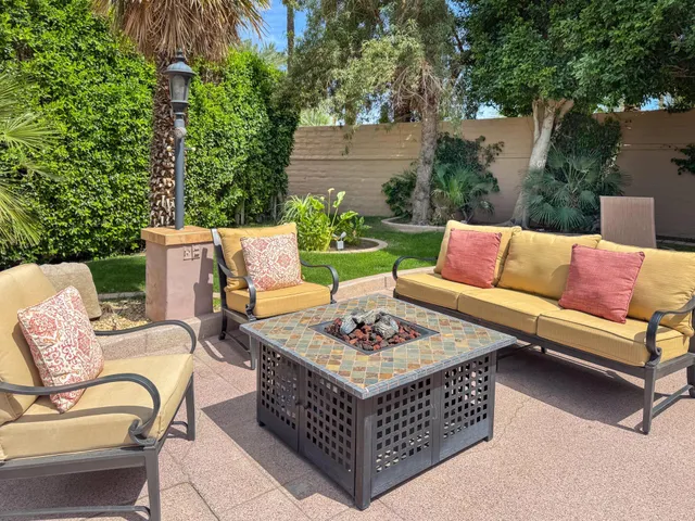 a outdoor space with patio couches and a potted plant on a table and chairs