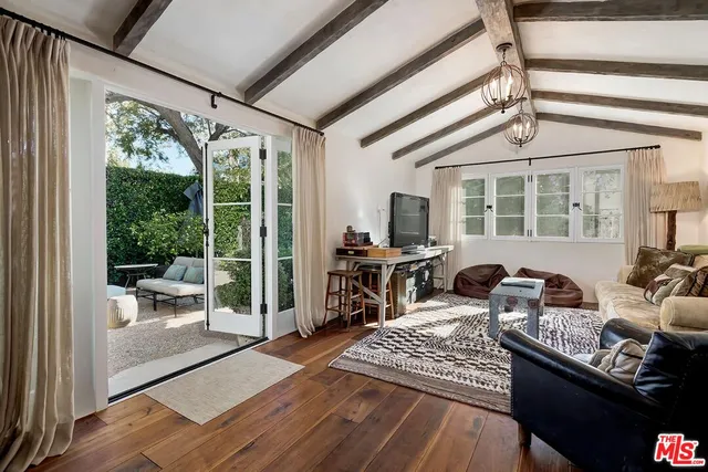 a living room with furniture large window and wooden floor
