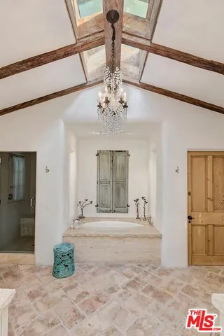 a spacious bathroom with a double vanity sink a toilet a mirror and shower