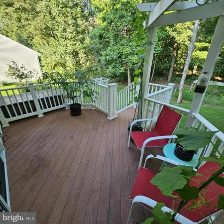 a balcony with chairs and wooden floor