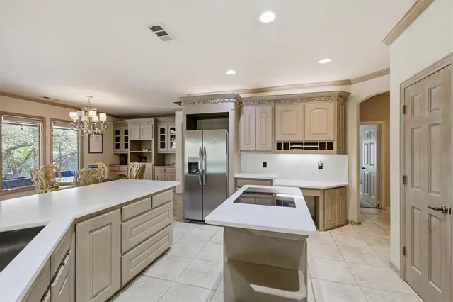 a large kitchen with stainless steel appliances lots of counter space and windows