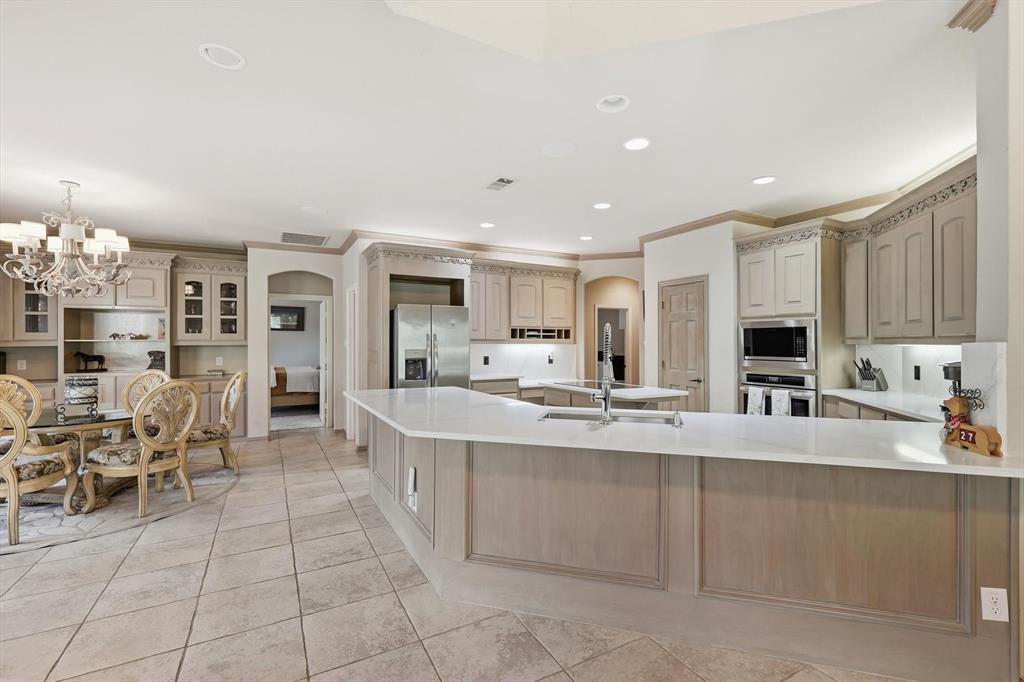 2740 High Road Flower Mound, TX 75022 - Photo 12 of 35 a large white kitchen with cabinets and chairs