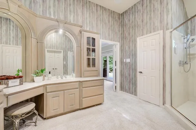 a en suite bathroom with a double vanity sink a large mirror and a shower