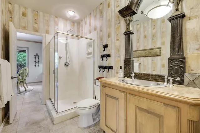 a bathroom with a granite countertop sink toilet and shower
