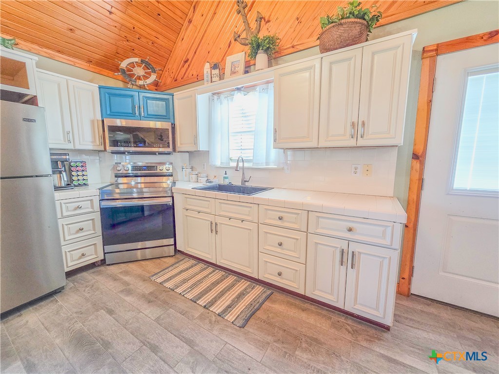 376 Haddock Drive Palacios, TX 77465 - Photo 5 of 41 a kitchen with cabinets appliances a sink and a window