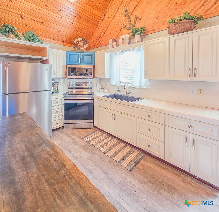 376 Haddock Drive Palacios, TX 77465 - Photo 6 of 41 a kitchen with granite countertop white cabinets and stainless steel appliances