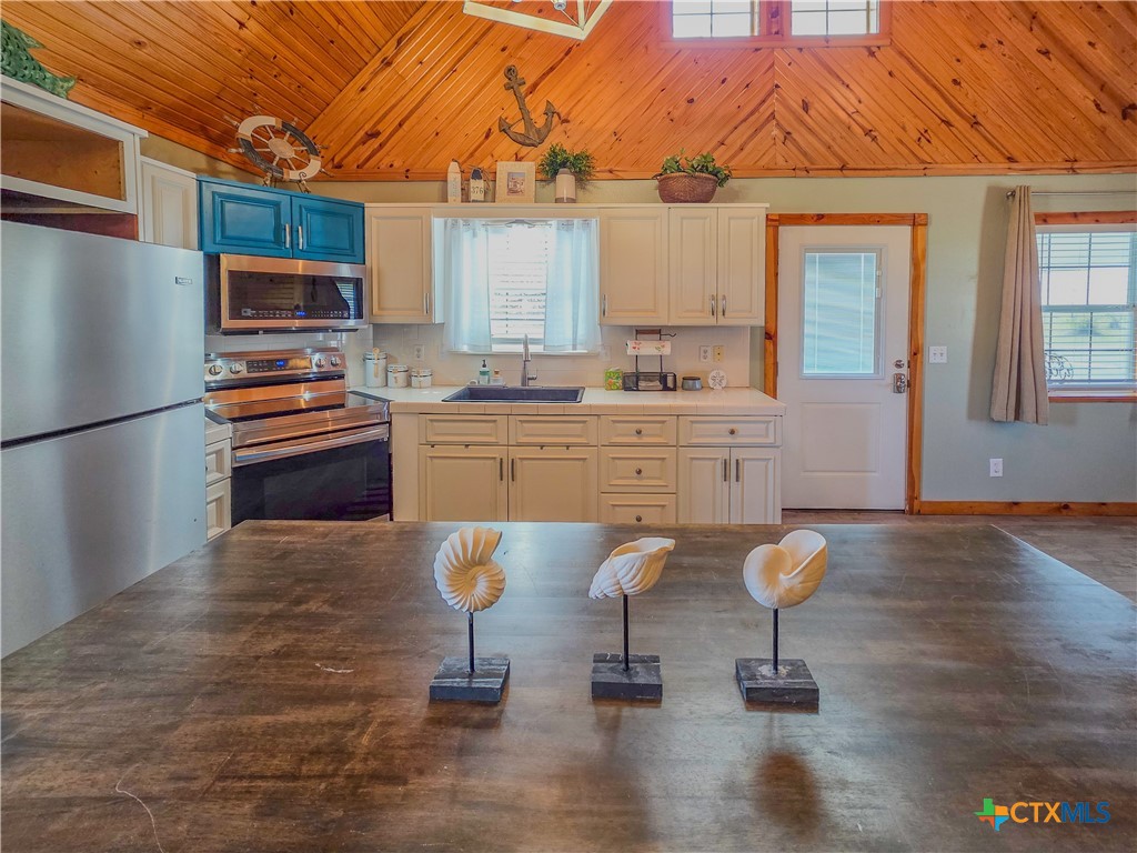 376 Haddock Drive Palacios, TX 77465 - Photo 9 of 41 a kitchen with stainless steel appliances a stove a sink cabinets and wooden floor