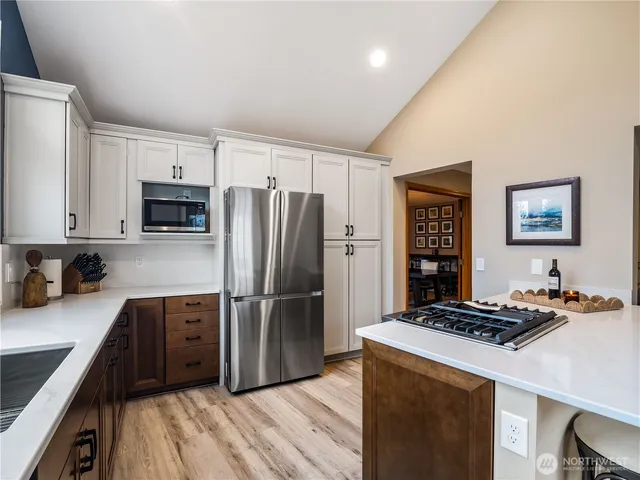 a kitchen with granite countertop a refrigerator stove and sink