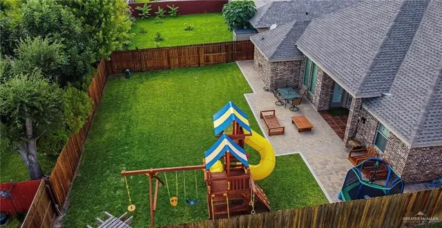 an aerial view of house with swimming pool and garden
