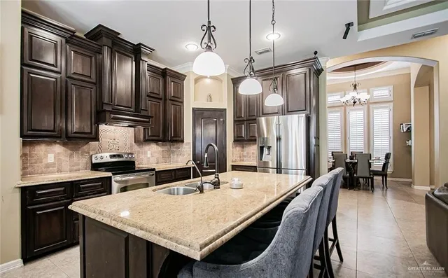 a kitchen with stainless steel appliances granite countertop a sink a stove and a refrigerator