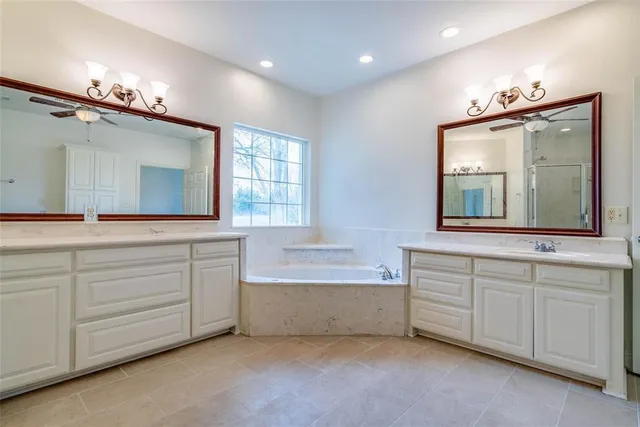 a bathroom with a sink double vanity mirror and a bathtub