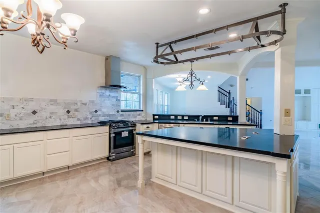 a kitchen with kitchen island granite countertop stainless steel appliances a sink and a stove