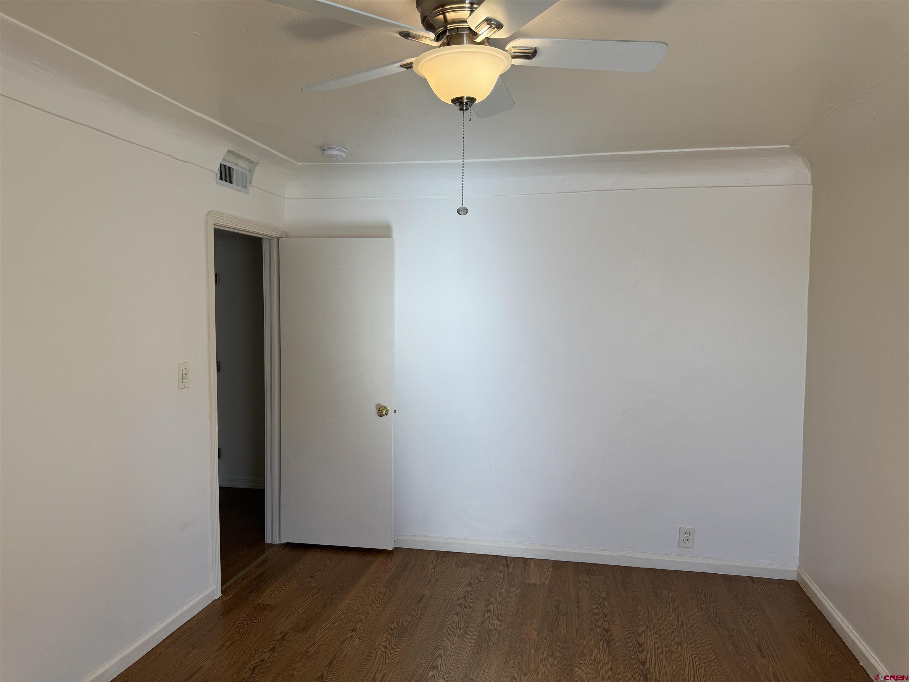 210 West Coronado Avenue Cortez, CO 81321 - Photo 11 of 41 a view of a room with wooden floor and a ceiling fan