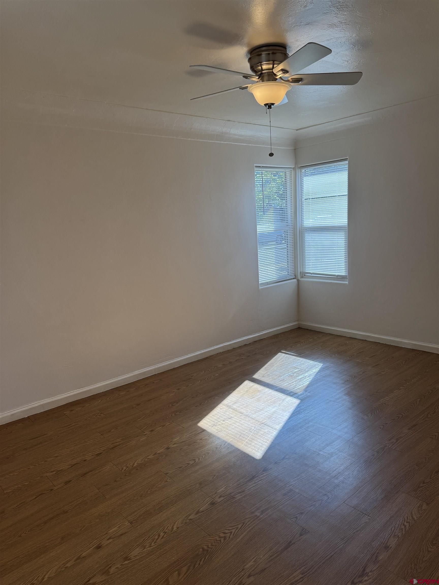 210 West Coronado Avenue Cortez, CO 81321 - Photo 12 of 41 wooden floor in an empty room with a window