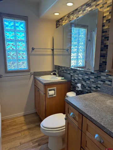a bathroom with a granite countertop toilet sink and mirror