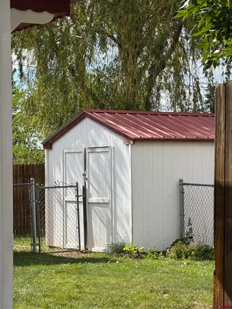 a view of backyard with small cabin and wooden fence