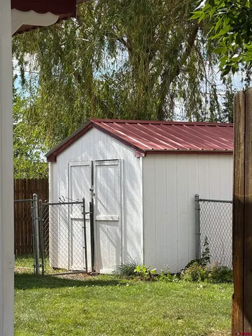 a view of backyard with small cabin and wooden fence