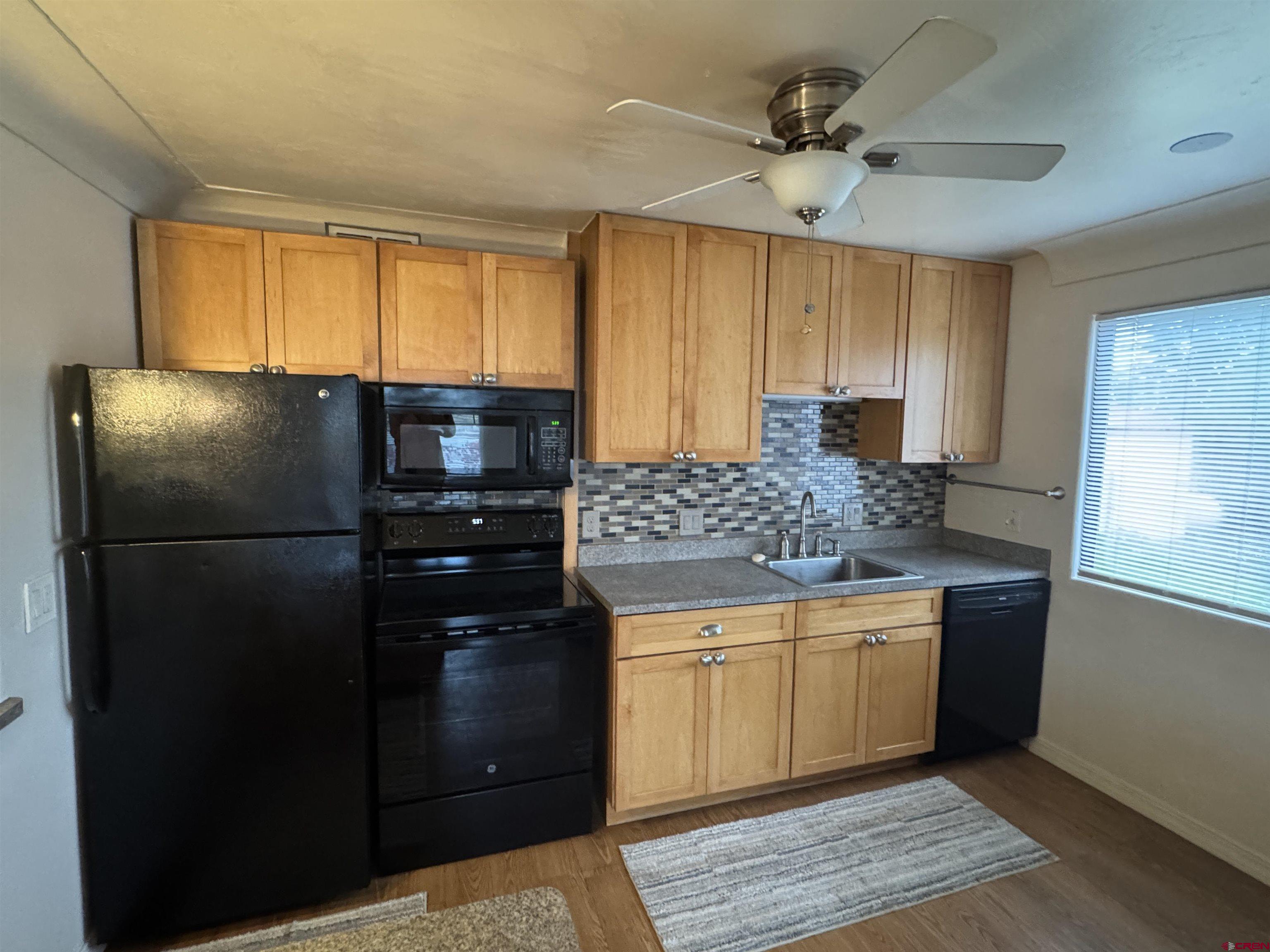 210 West Coronado Avenue Cortez, CO 81321 - Photo 3 of 41 a kitchen with a refrigerator and a sink