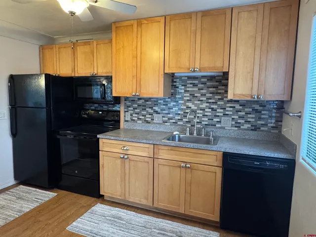 a kitchen with a sink a refrigerator and cabinets