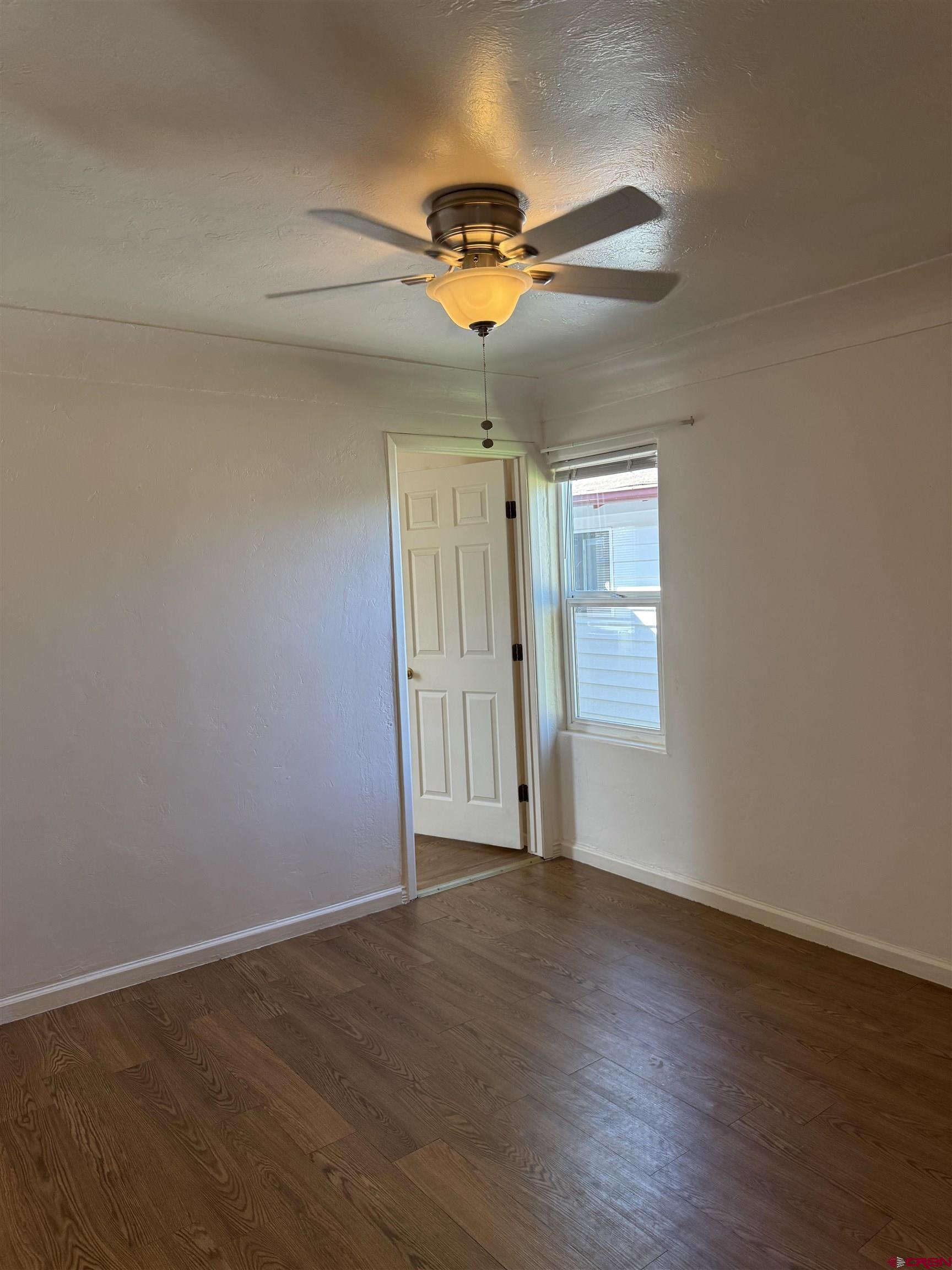 210 West Coronado Avenue Cortez, CO 81321 - Photo 7 of 41 a view of a livingroom with wooden floor and a ceiling fan