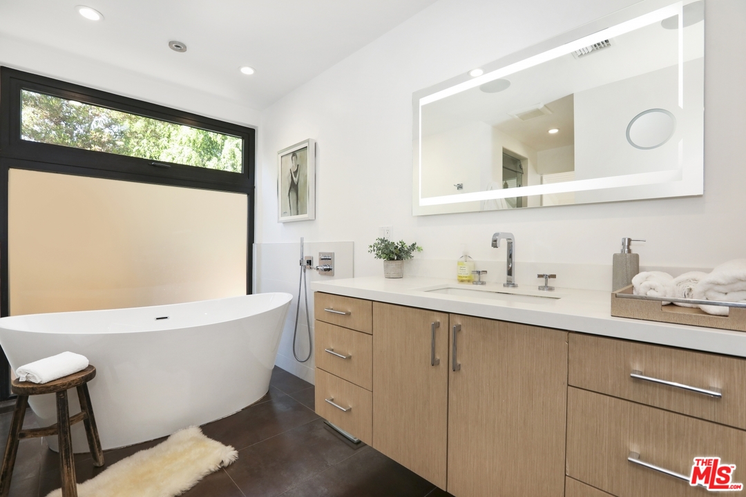 2425 Rinconia Drive Los Angeles, CA 90068 - Photo 15 of 32 a bathroom with a bathtub a mirror a sink and double vanity