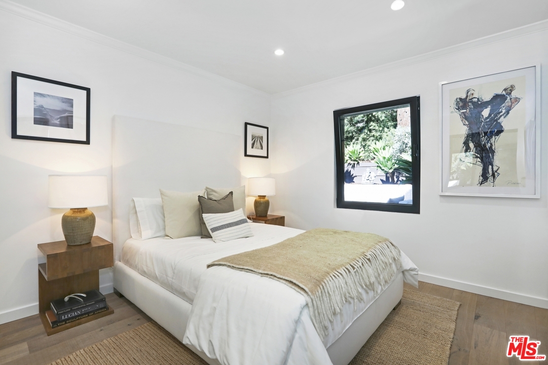 2425 Rinconia Drive Los Angeles, CA 90068 - Photo 16 of 32 a bedroom with a bed and a painting on the wall