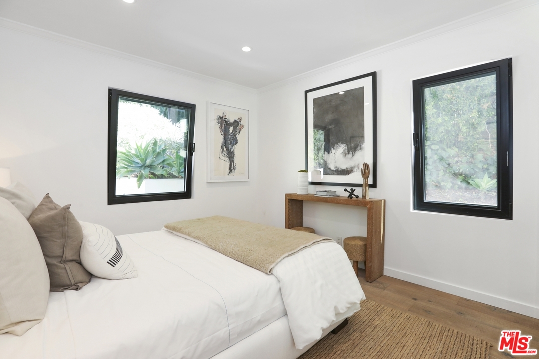 2425 Rinconia Drive Los Angeles, CA 90068 - Photo 17 of 32 a bedroom with a bed and a painting on the wall