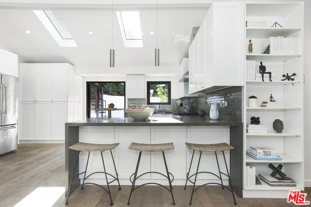 2425 Rinconia Drive Los Angeles, CA 90068 - Photo 9 of 32 a kitchen with stainless steel appliances a table and chairs in it