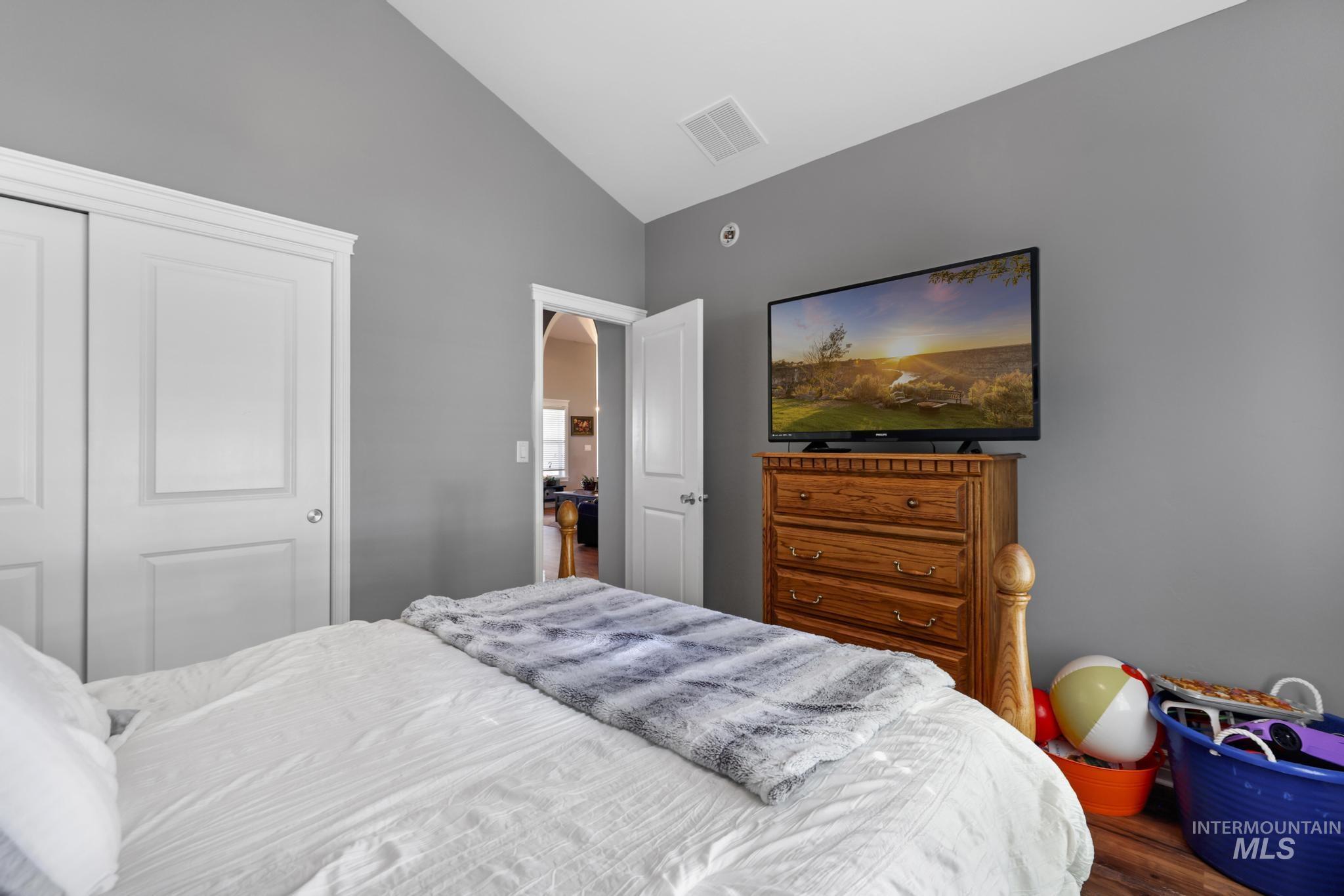 467 Wildrose Loop Twin Falls, ID 83301 - Photo 19 of 46 Room featuring vaulted ceiling, gray painted walls, and wood-finish flooring