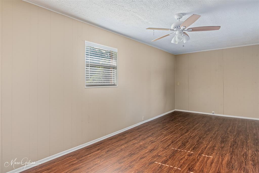 9342 Dean Road Shreveport, LA 71118 - Photo 15 of 18 Bonus room featuring wood-finish flooring, light-colored vertical paneling, a window with horizontal blinds, and a ceiling fan with integrated lighting
