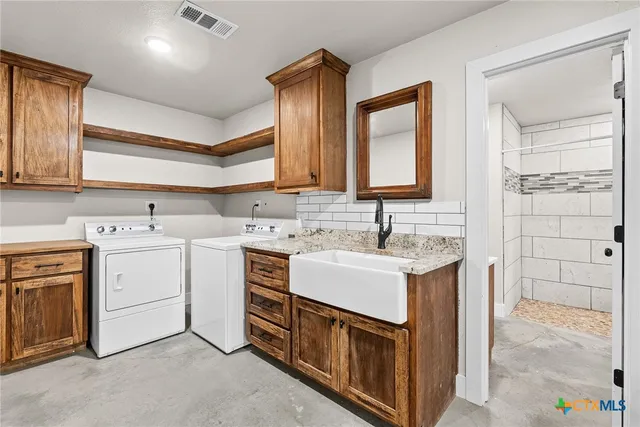 a utility room with cabinets washer and dryer
