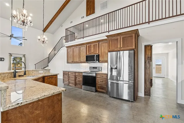 a kitchen with kitchen island a counter top space appliances and cabinets