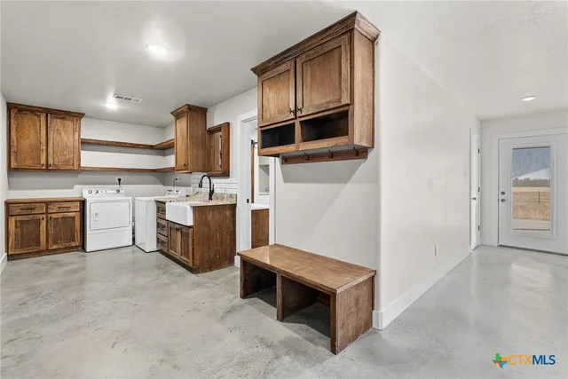 a kitchen with stainless steel appliances kitchen island wooden cabinets and entryway