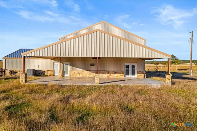 a view of a house with backyard and sitting area