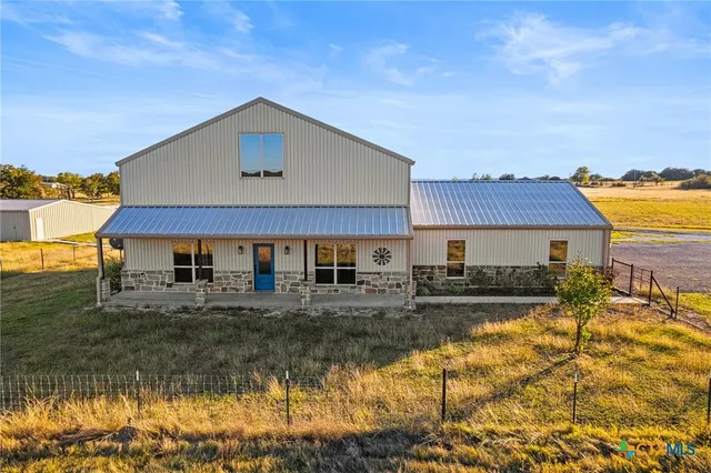 a view of a big house with big yard and large tree
