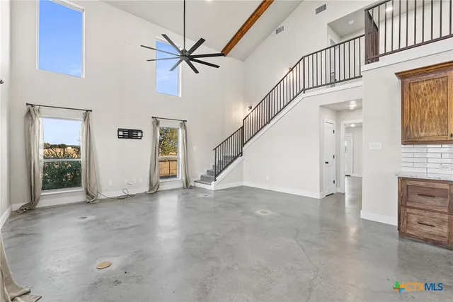 wooden floor with a chandelier fan and a fireplace