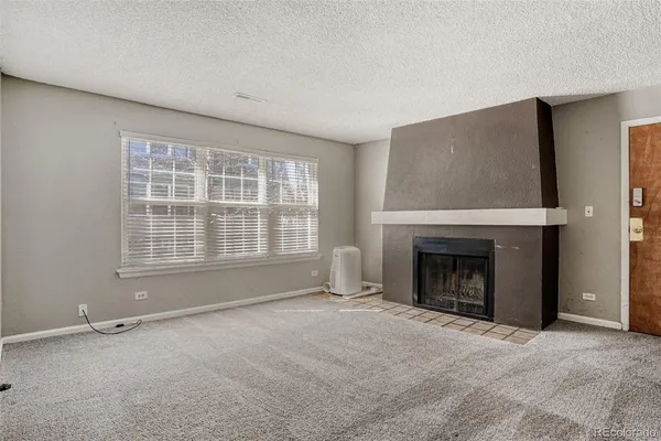 wooden floor fireplace and windows in an empty room