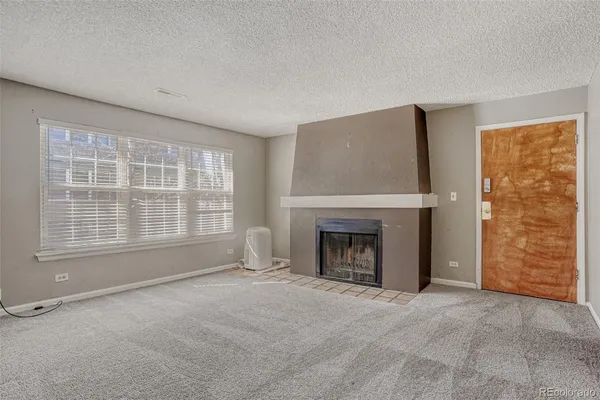 a view of an empty room with a fireplace and a window